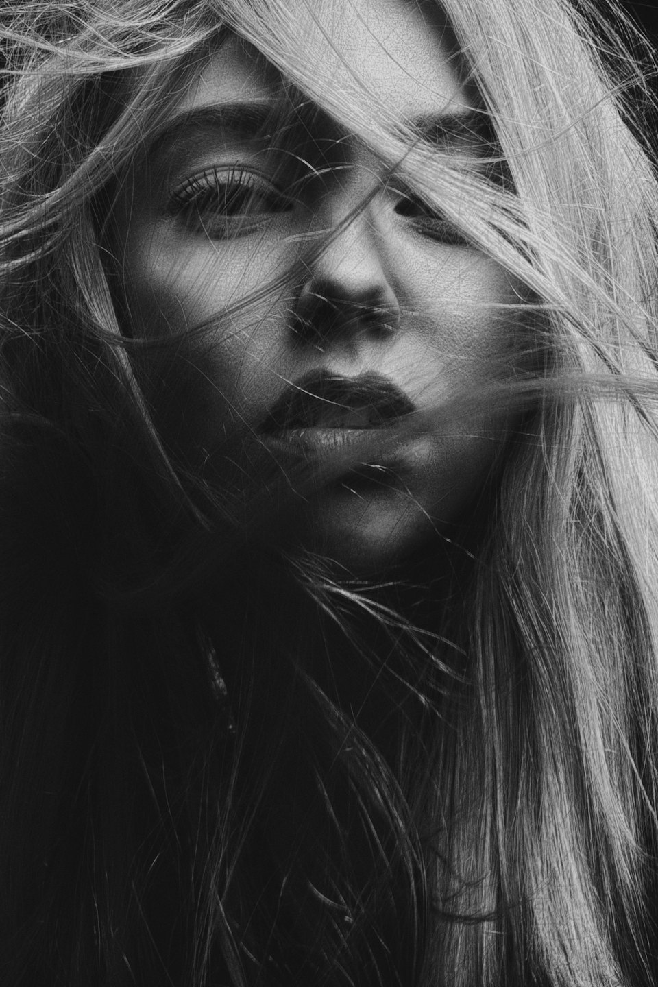 Young woman with long hair swirling around her face.